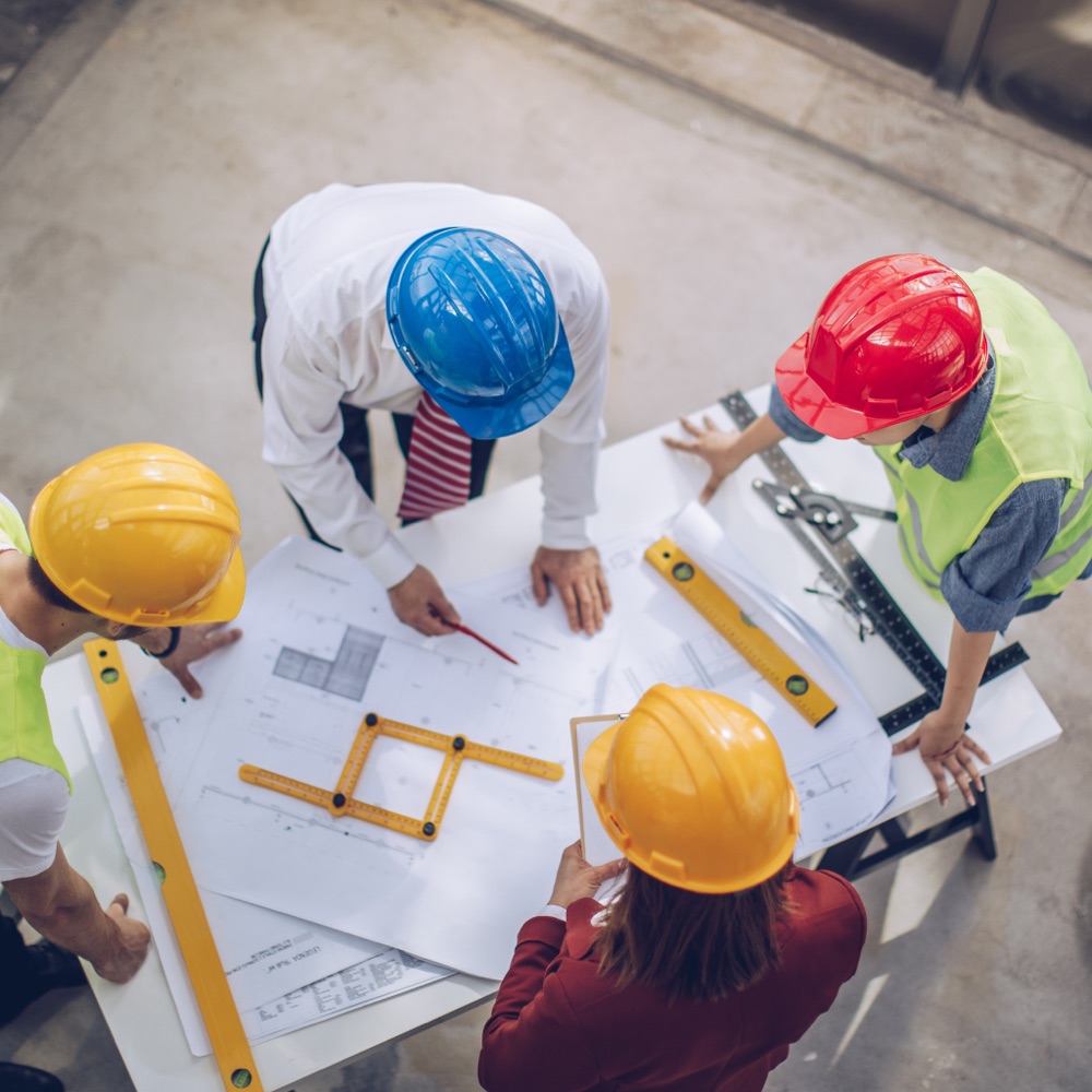 Project team collaborating around construction plans